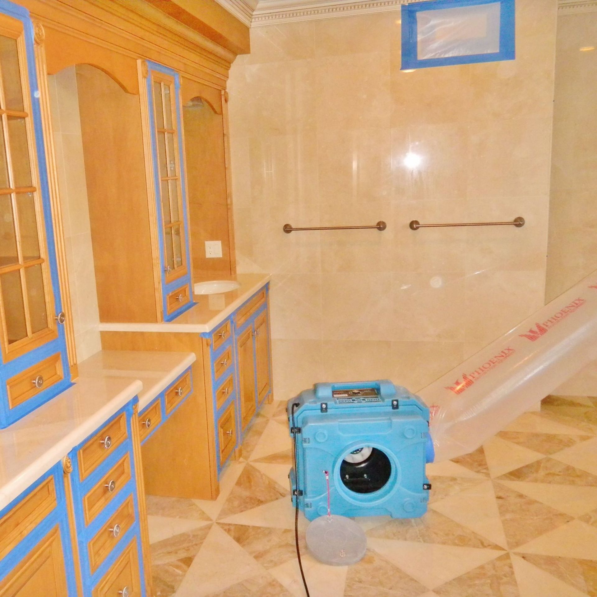 Mold Remediation Inc -A bathroom with a blue box on the floor that says ' warning ' on it