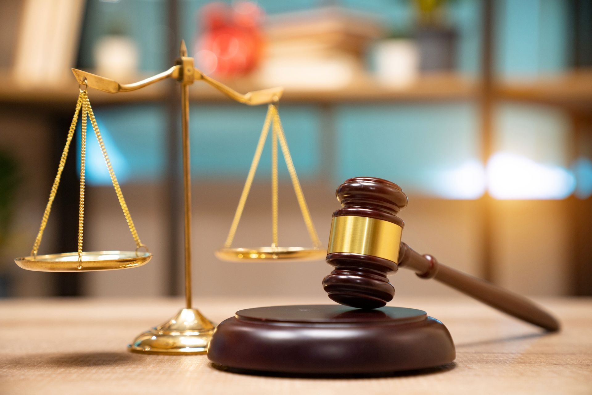 Gold scales and a gavel on a wooden desk, symbolizing justice and law.