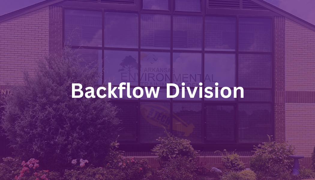 Purple-tinted building facade with the words “Backflow Division” centered across it.
