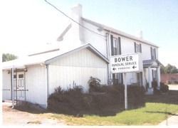 White building with a sign reading “Bower” on a sunny street corner