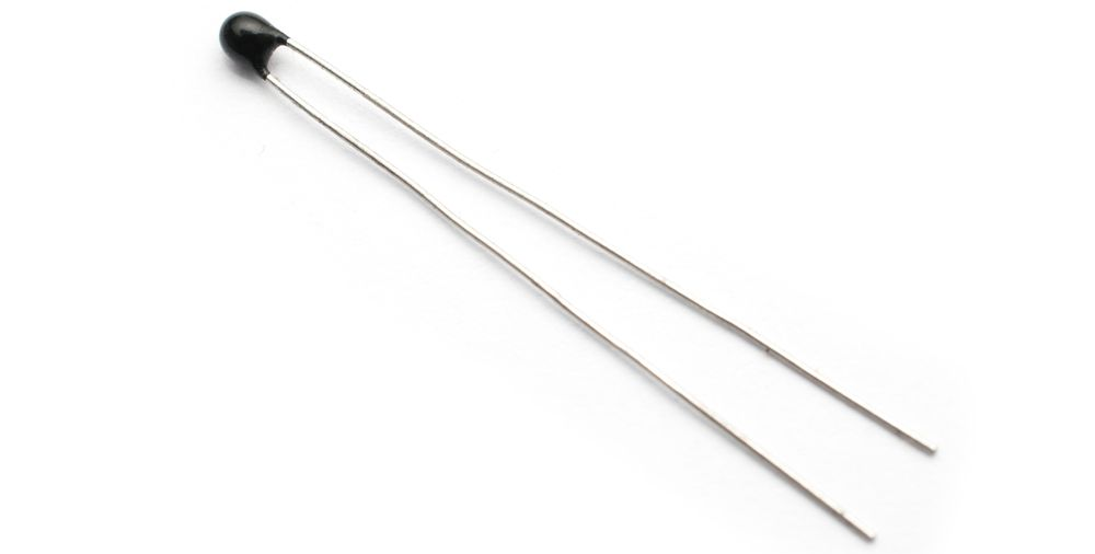 Black-and-silver electronic component with two long metal leads on a white background