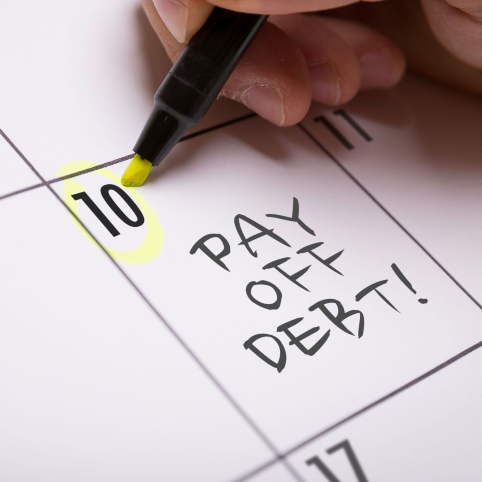 Hand highlighting a calendar date (10) with a yellow marker, next to 