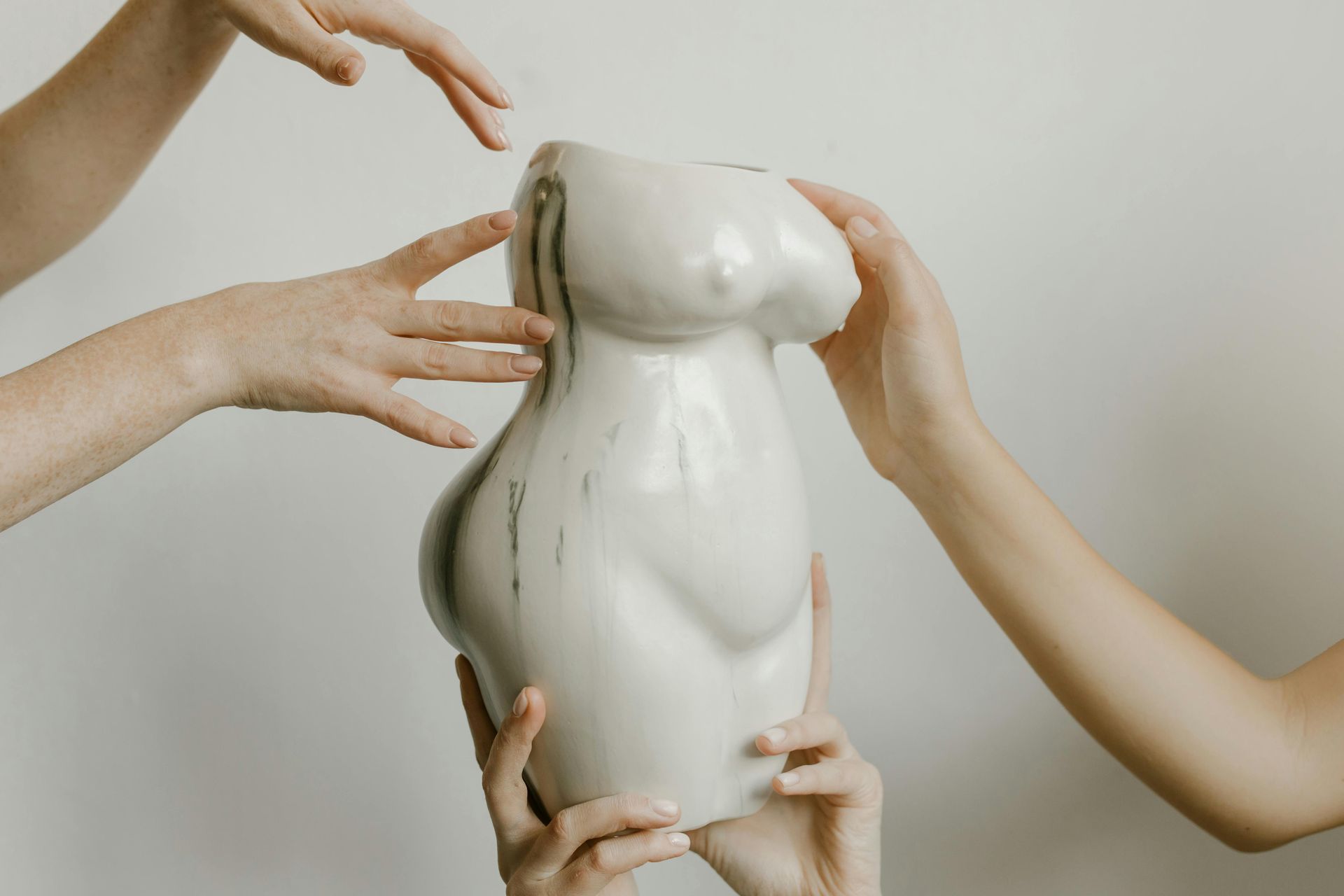 Persona sottoposta a trattamento di rimodellamento del corpo con un dispositivo portatile, mano guantata.