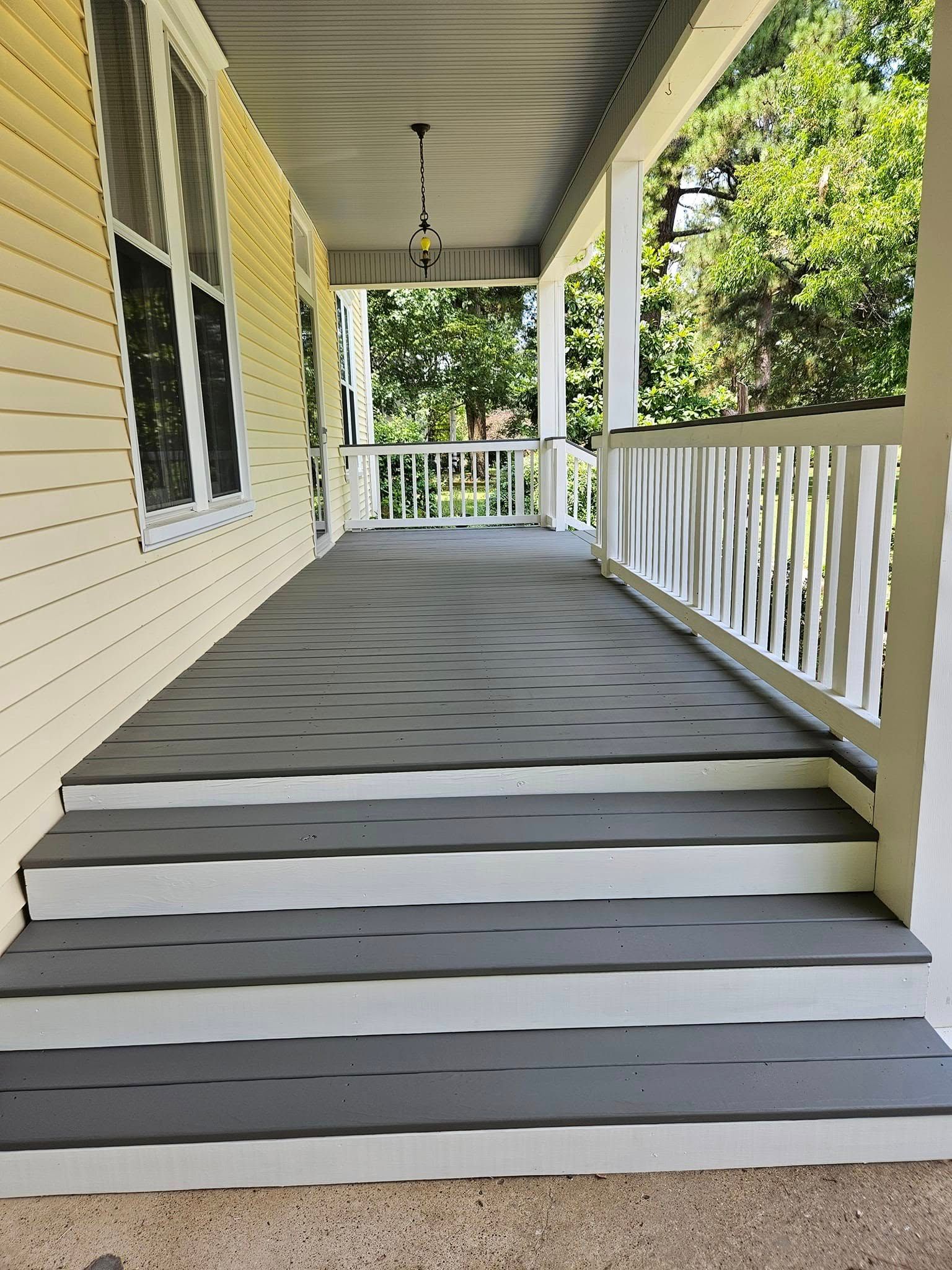 Gray and white porch with steps, a railing, and a covered ceiling.