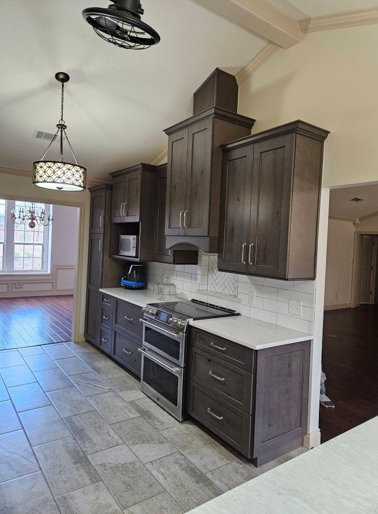 Kitchen with dark gray cabinets, white countertops, and stainless steel appliances.
