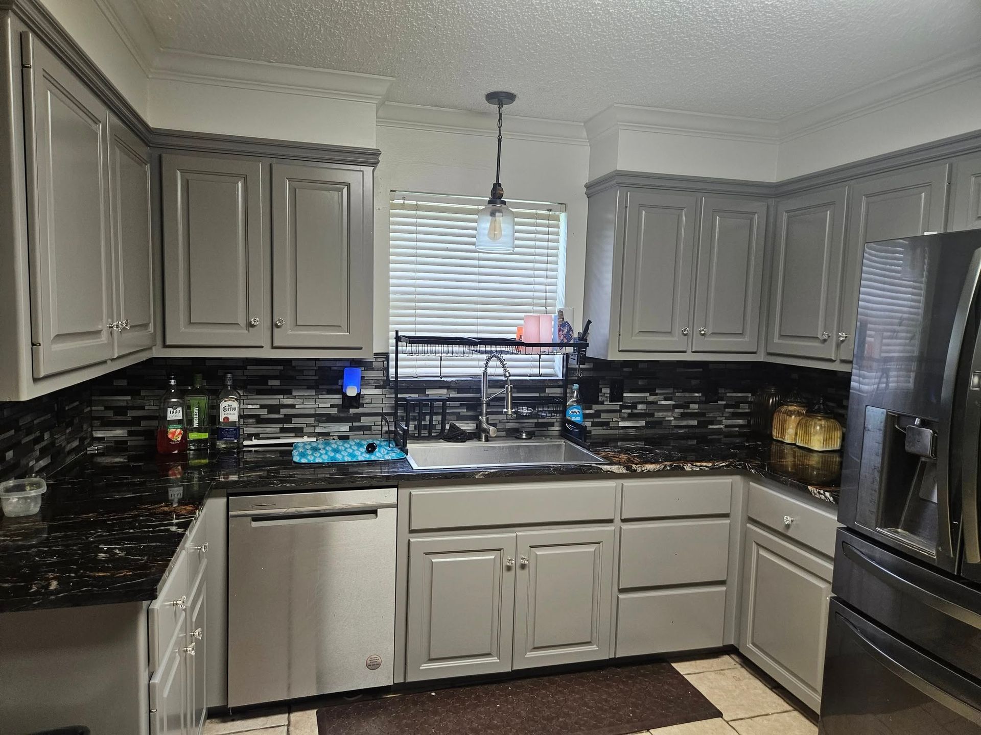 Gray kitchen with granite countertops, stainless steel appliances, and gray cabinets.
