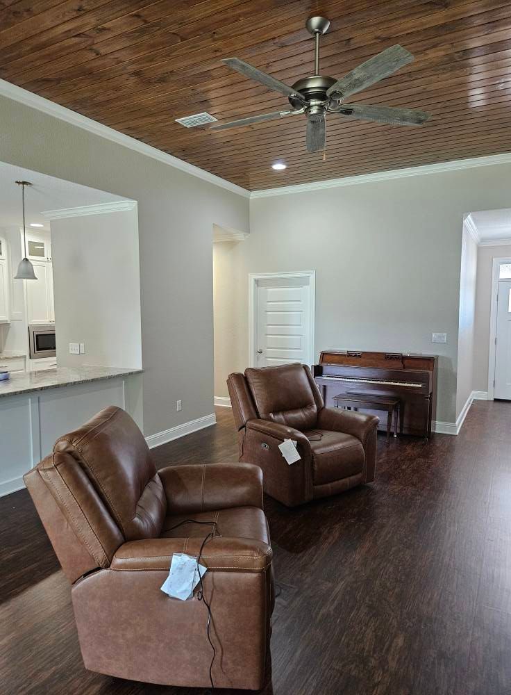 Two brown leather recliners in a living room with a wood ceiling, piano, and fan.