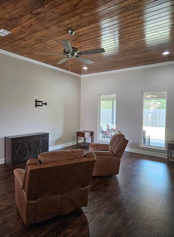 Living room with wooden ceiling, brown furniture, and two recliners.