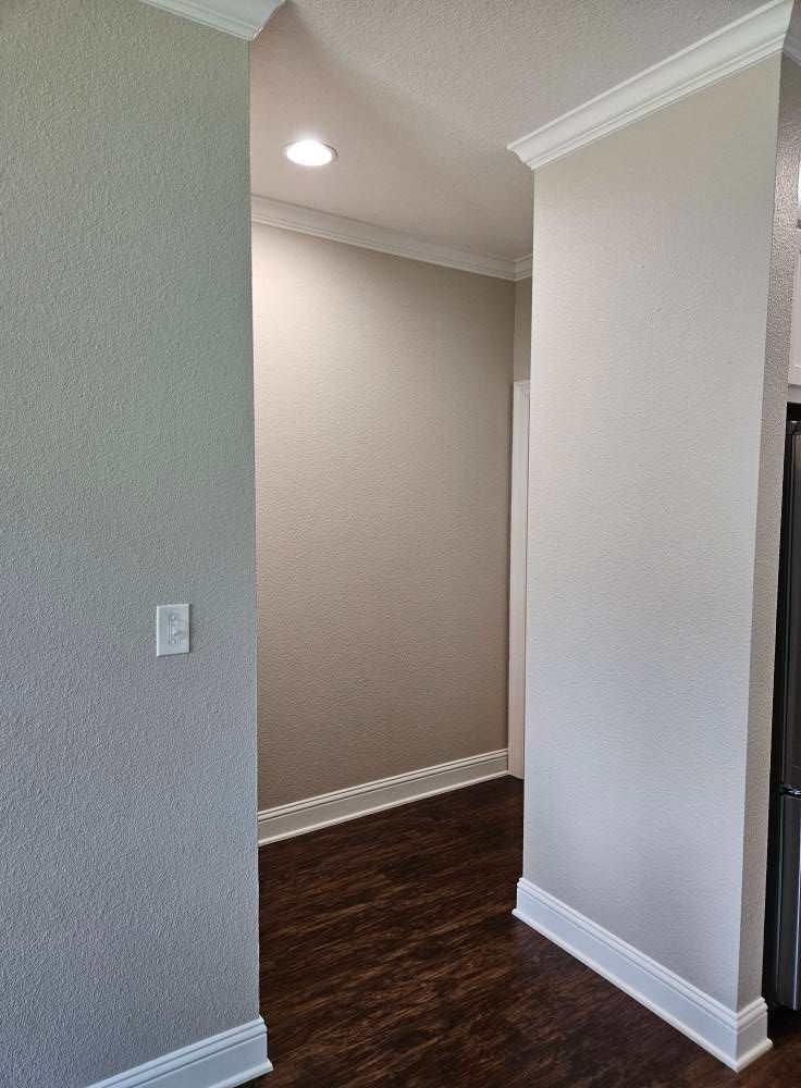 Hallway with wood floors, light walls, and white trim.