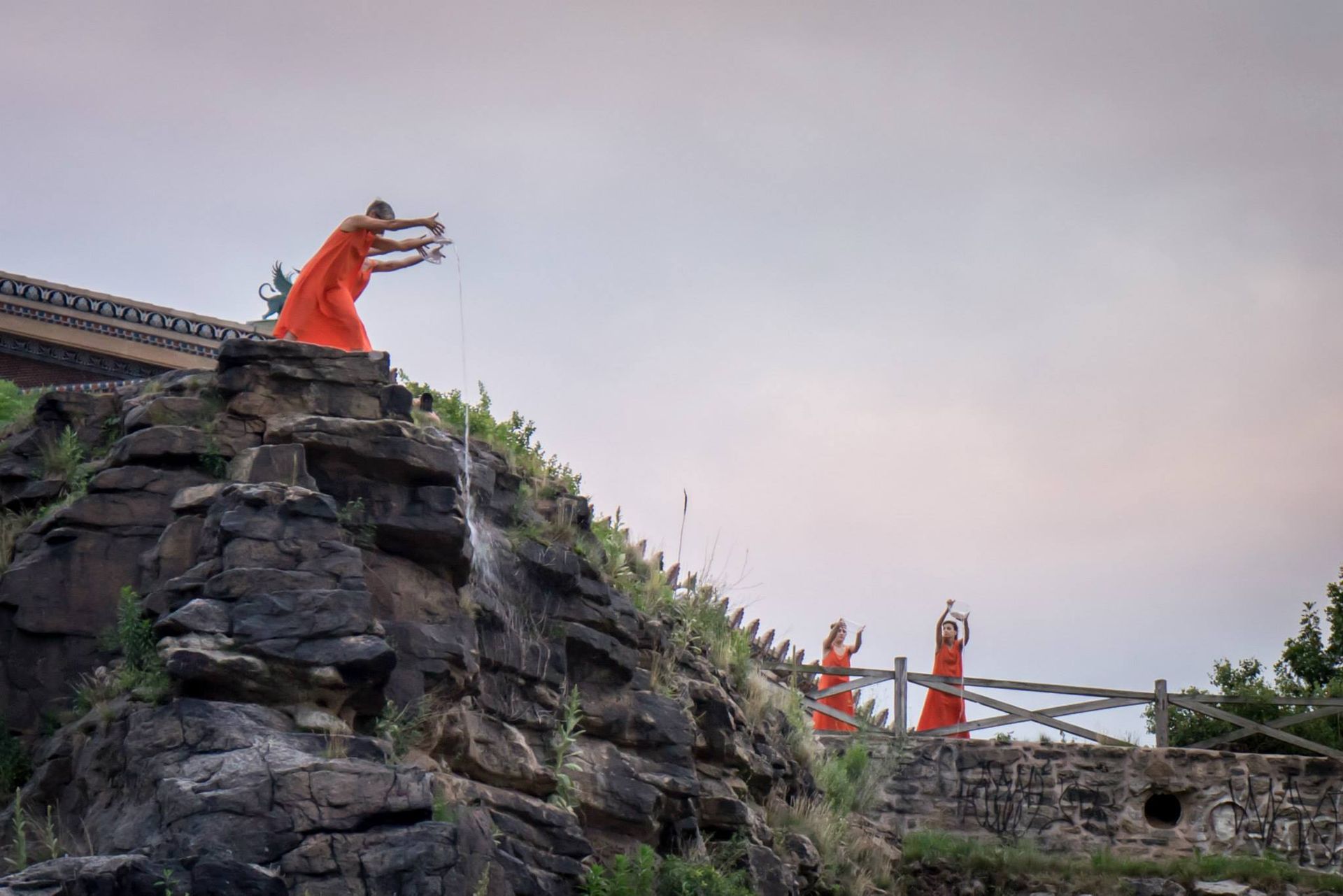 A group of monks are practicing martial arts on top of a rocky hill.