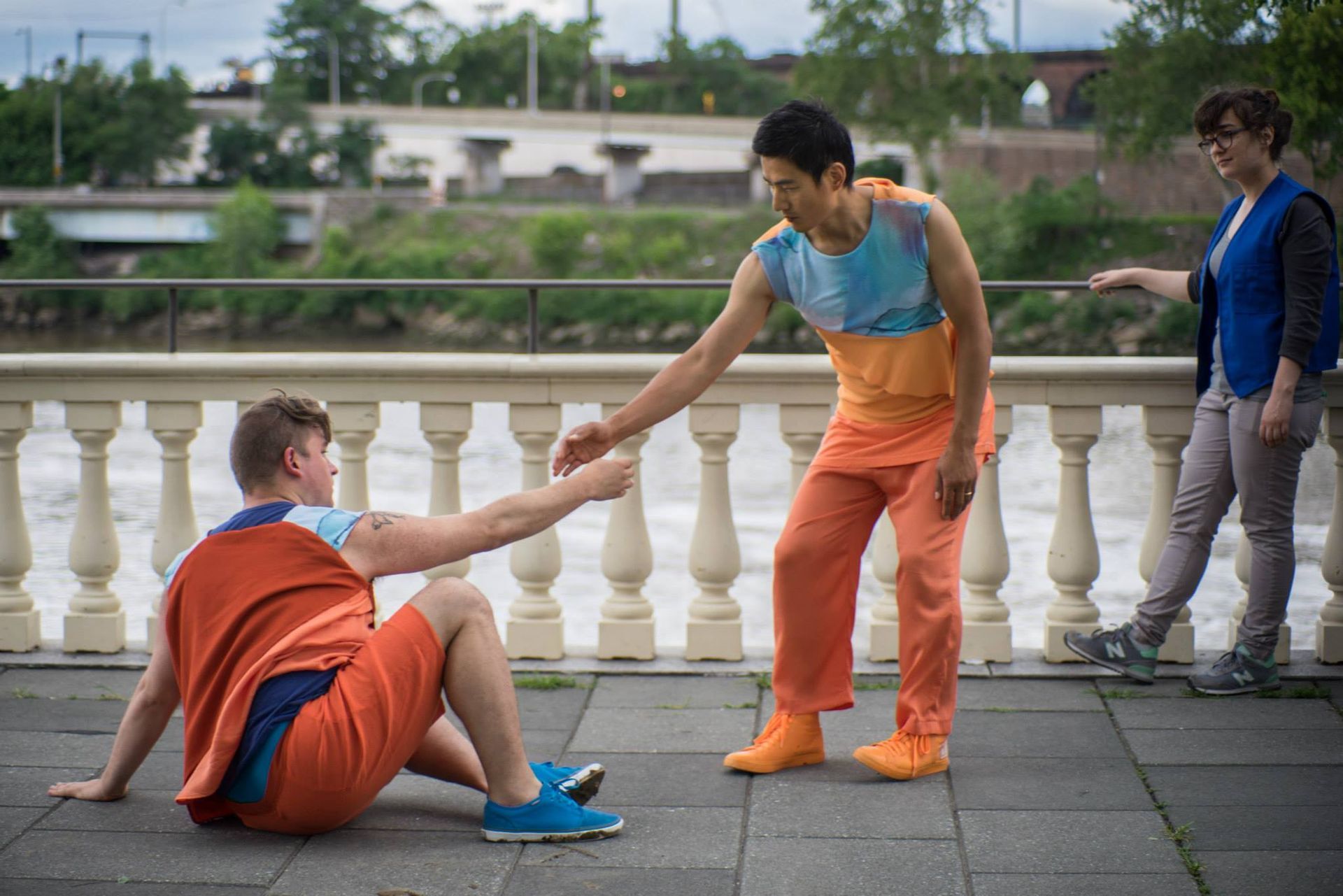 A man is helping another man up from the ground.