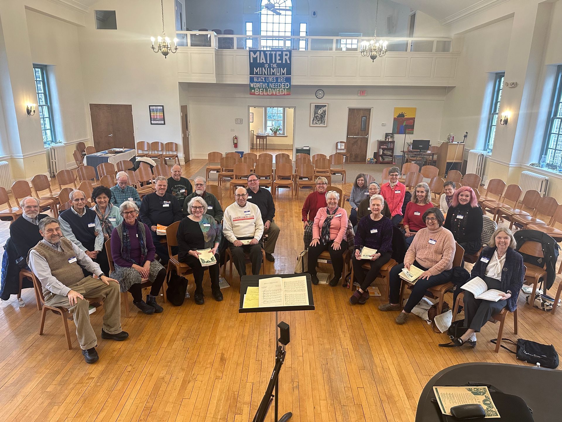 A group of people are sitting in chairs in a large room.