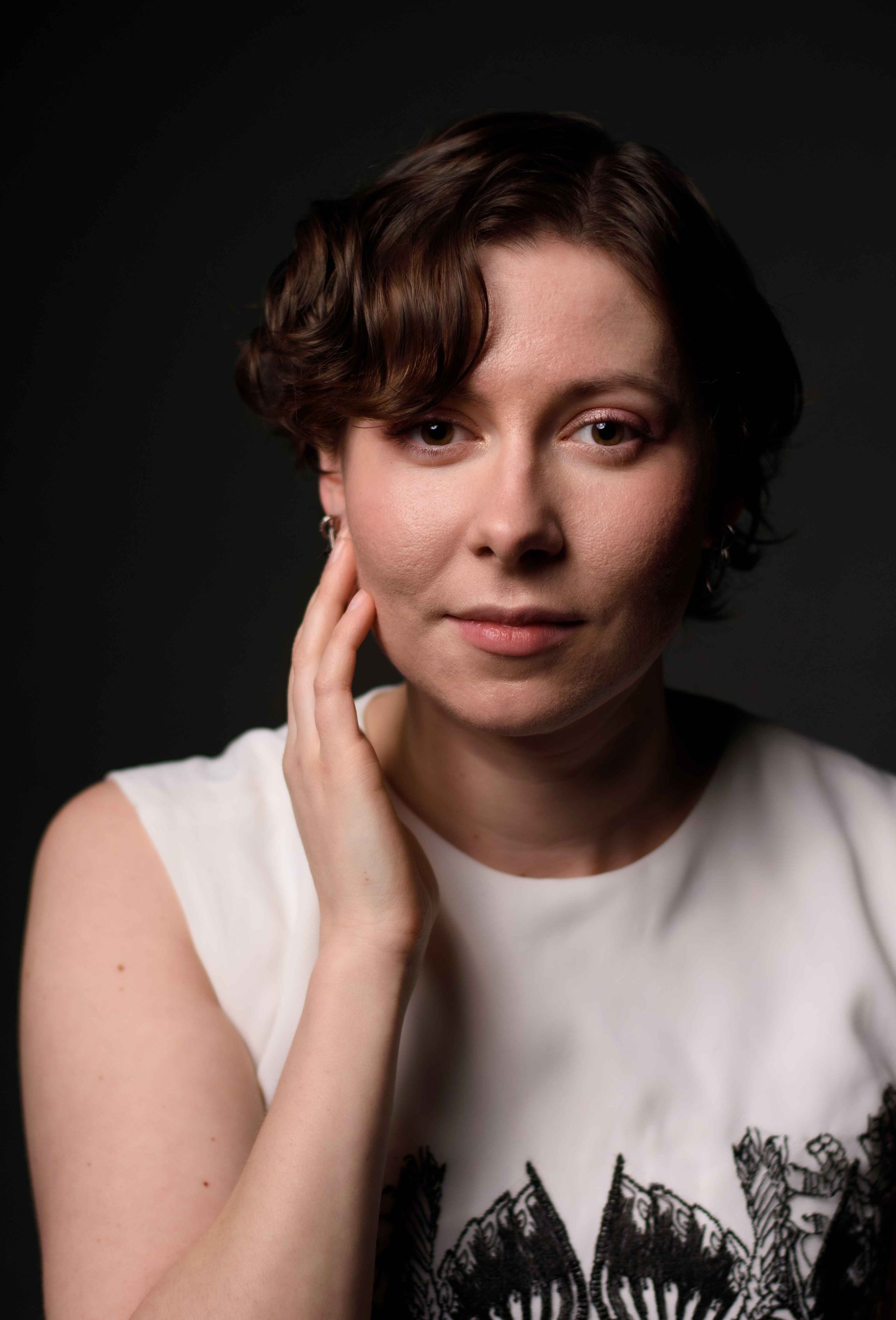 A woman in a red off the shoulder dress is looking at the camera