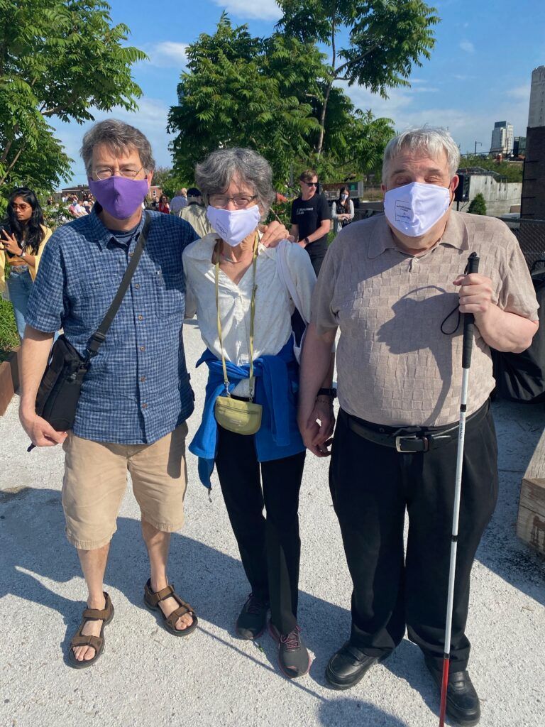 A group of people wearing face masks are standing next to each other.
