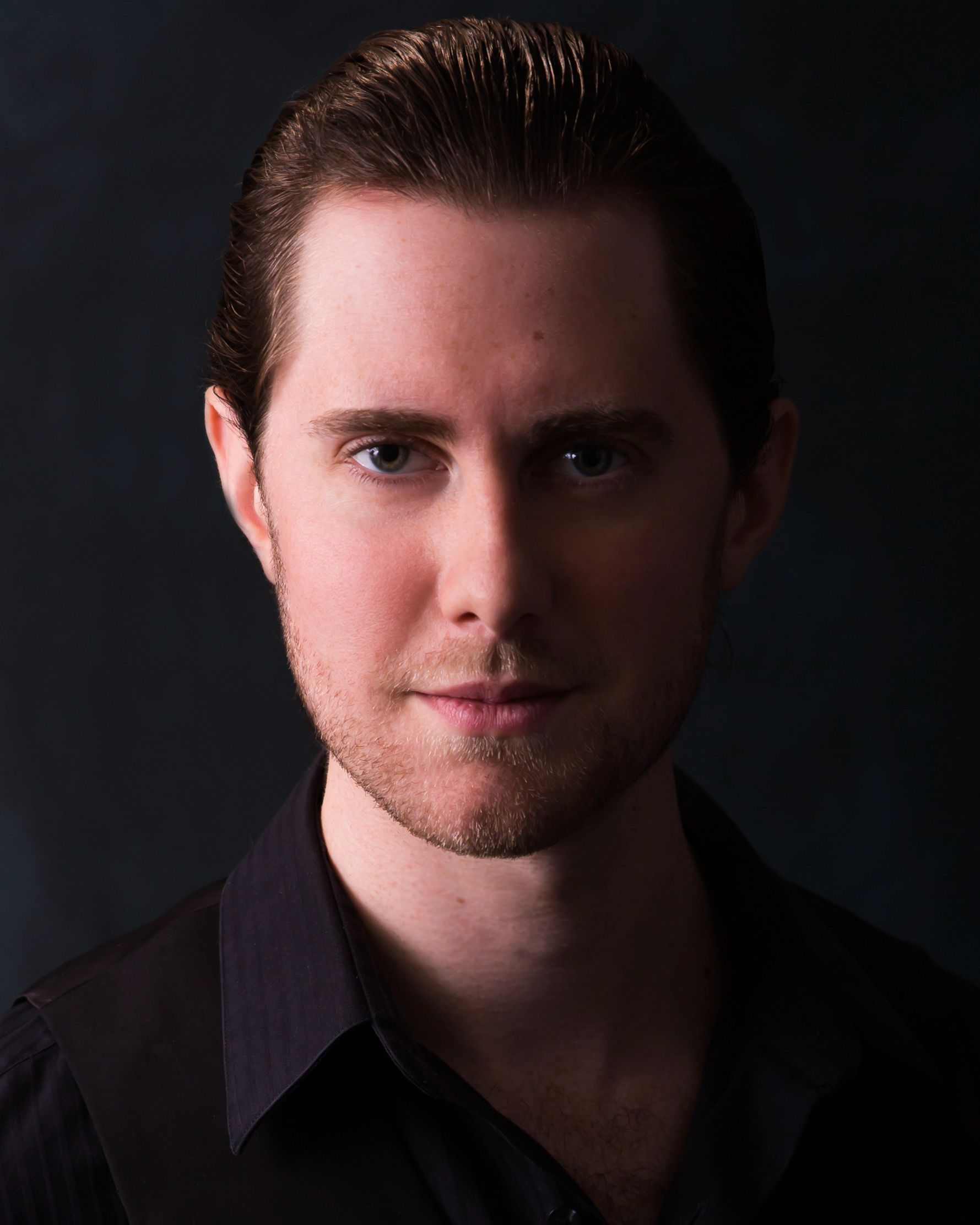 A man with a beard is wearing a black shirt