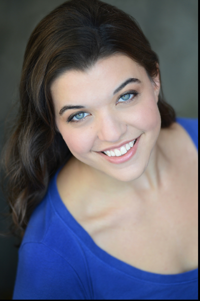 A woman in a blue shirt is smiling for the camera