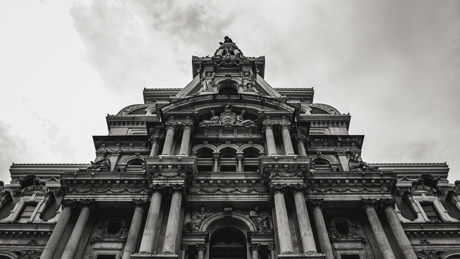 Low-angle view of an ornate historic stone building against a cloudy sky