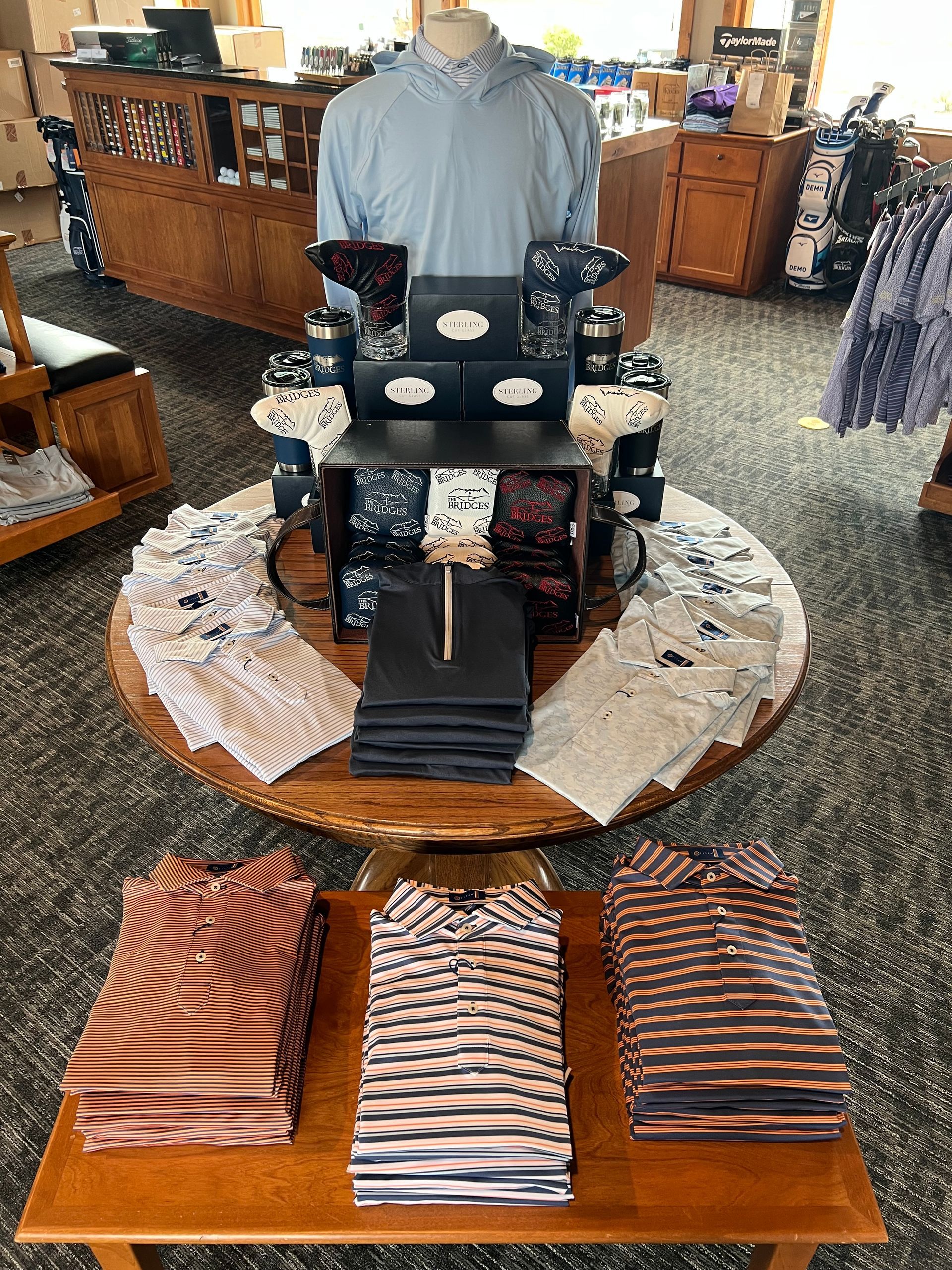 Golf apparel display in a golf shop. Shirts stacked on tables in various colors.