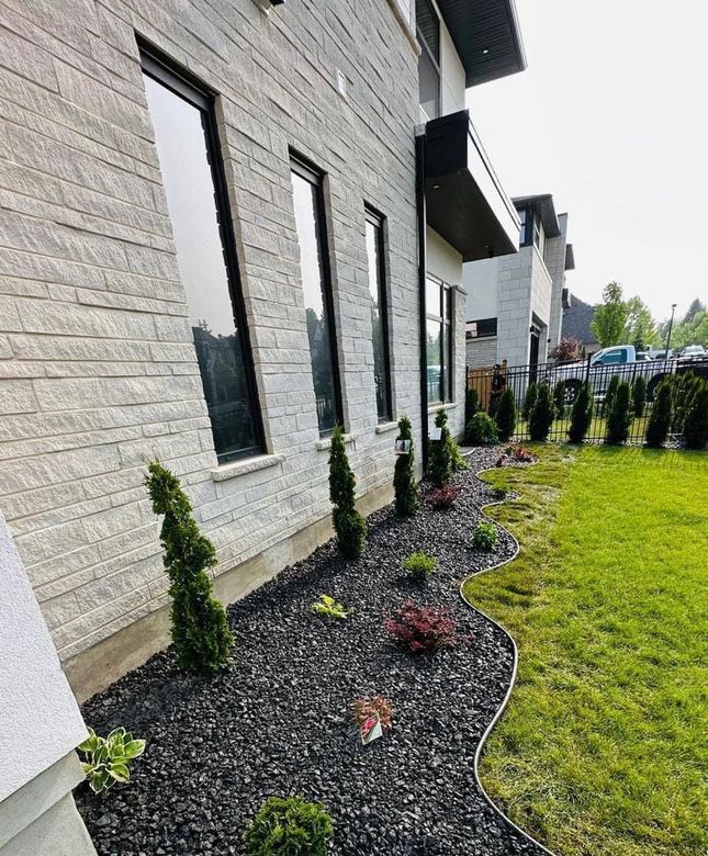 A house with a lot of windows and a lush green yard.