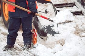 A man shoveling snow from a pathway. 