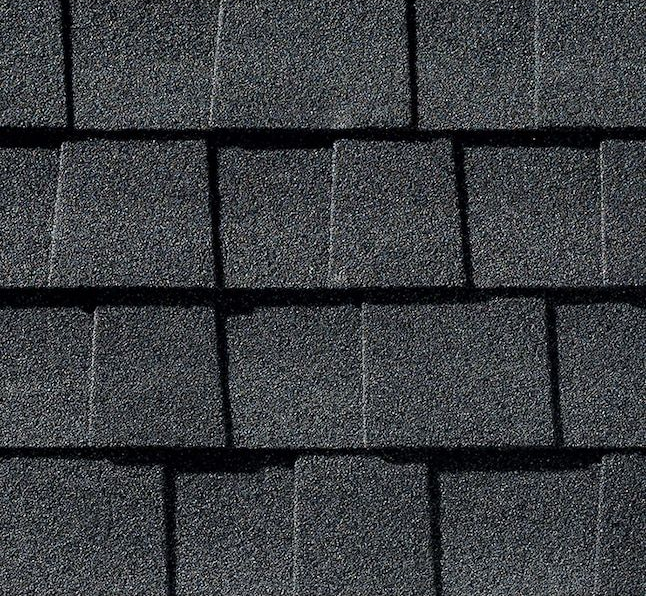 A close-up of dark grey, overlapping asphalt architectural shingles on a roof.