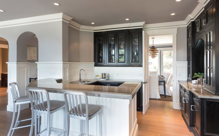 Modern kitchen with white island, gray walls, dark cabinets, and hardwood floors