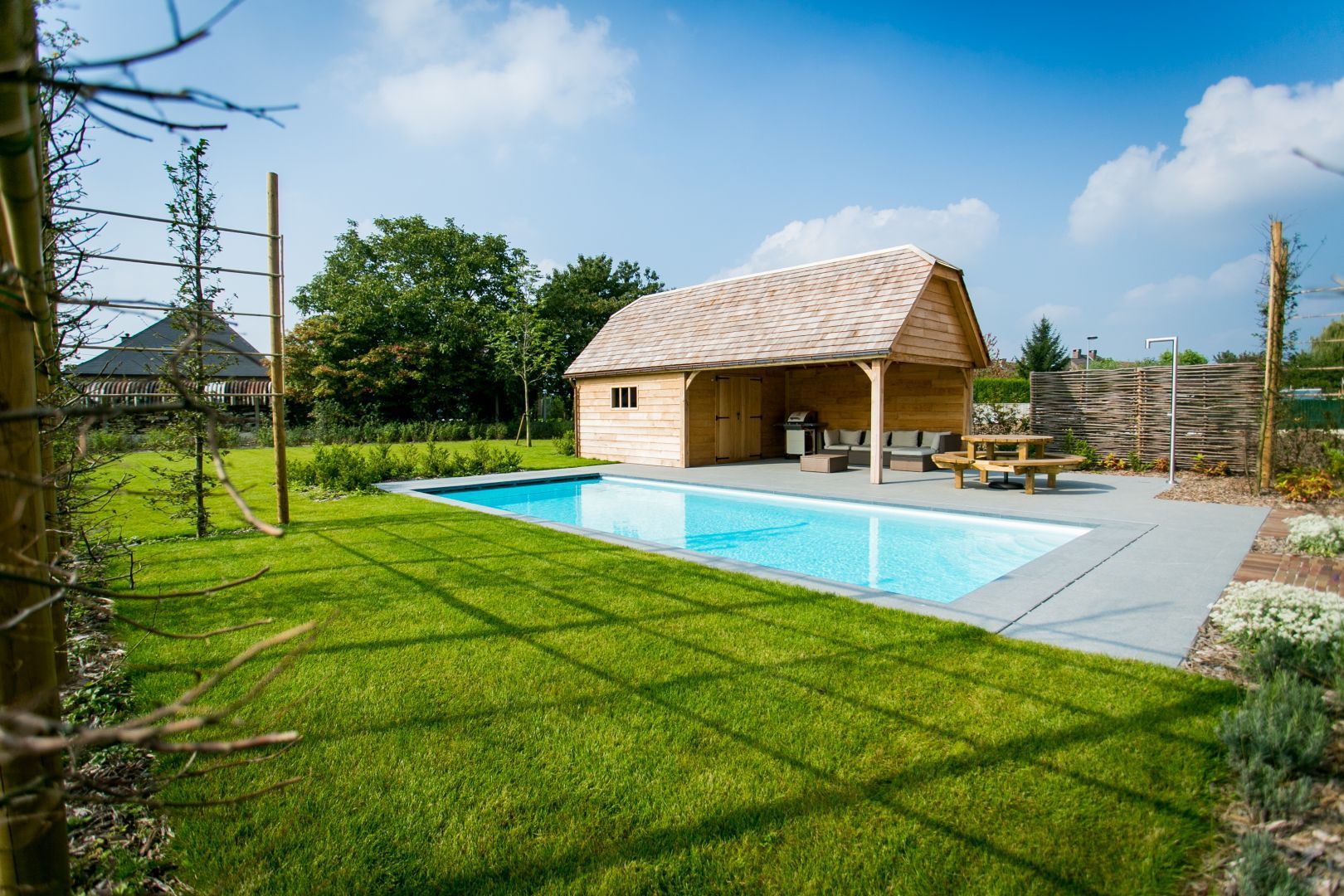 Stor glasfiber swimmingpool ved siden af en hytte.