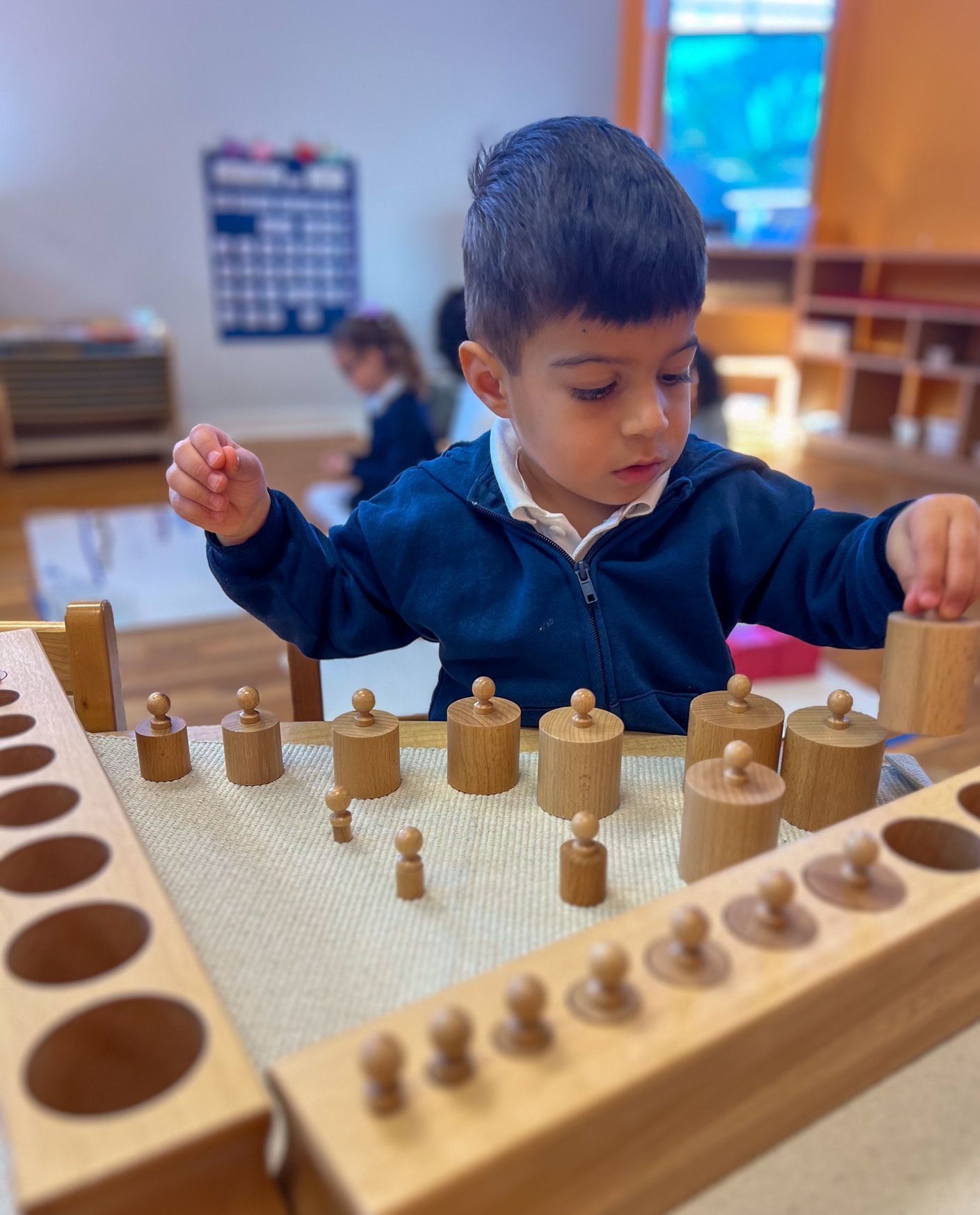 Child working with Montessori cylinder blocks