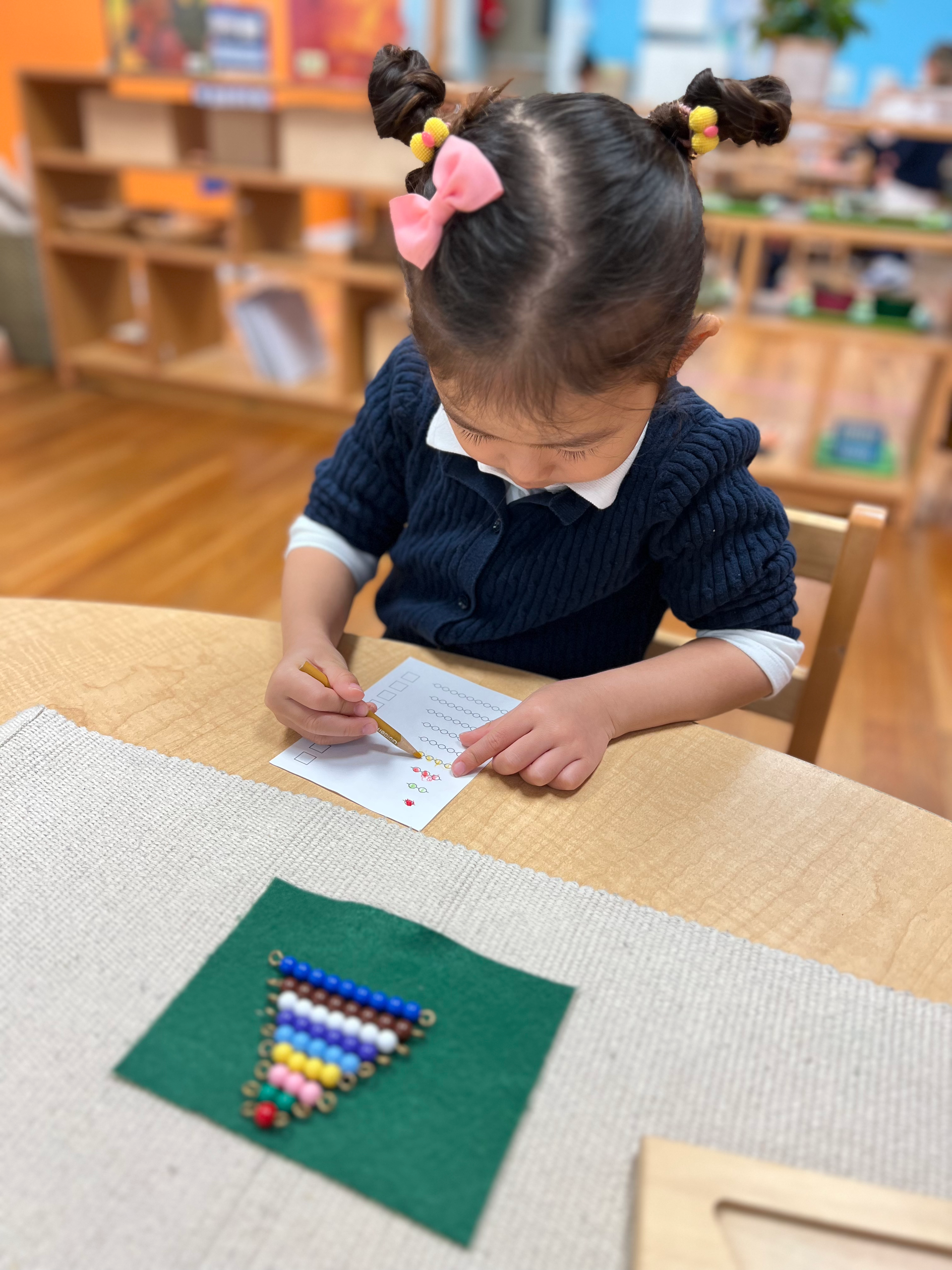 Montessori child learnig maths with Montessori binomial cube