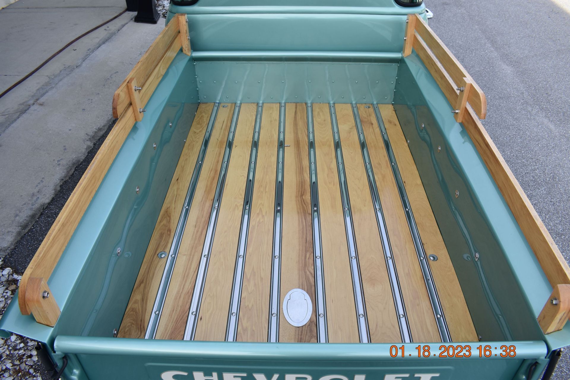 Teal Chevrolet pickup truck bed with wooden slat floor and side rails
