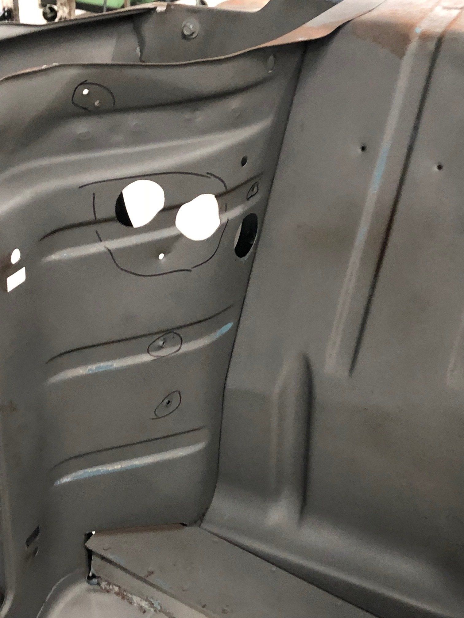 Interior side panel of a vehicle trunk or cargo area with two circular cutouts and a black trim edge