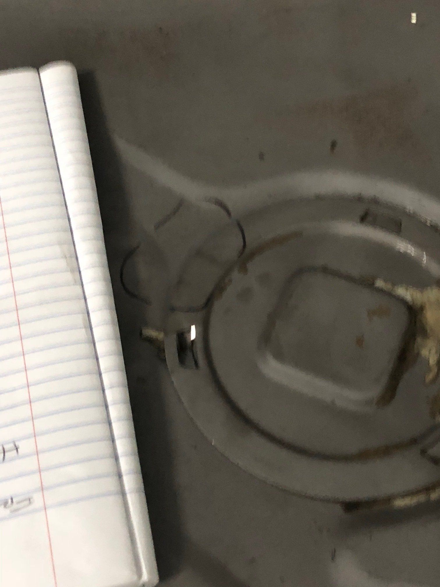 Notebook beside a clear glass ashtray on a dark surface