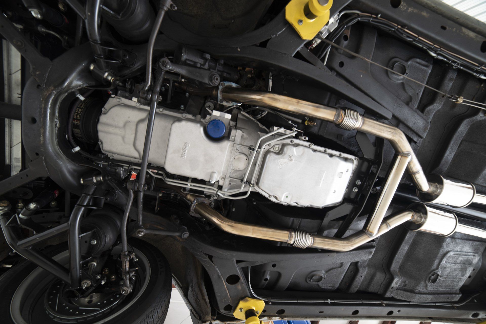 Undercarriage of a vehicle, showing exhaust, fuel tank, and suspension components.