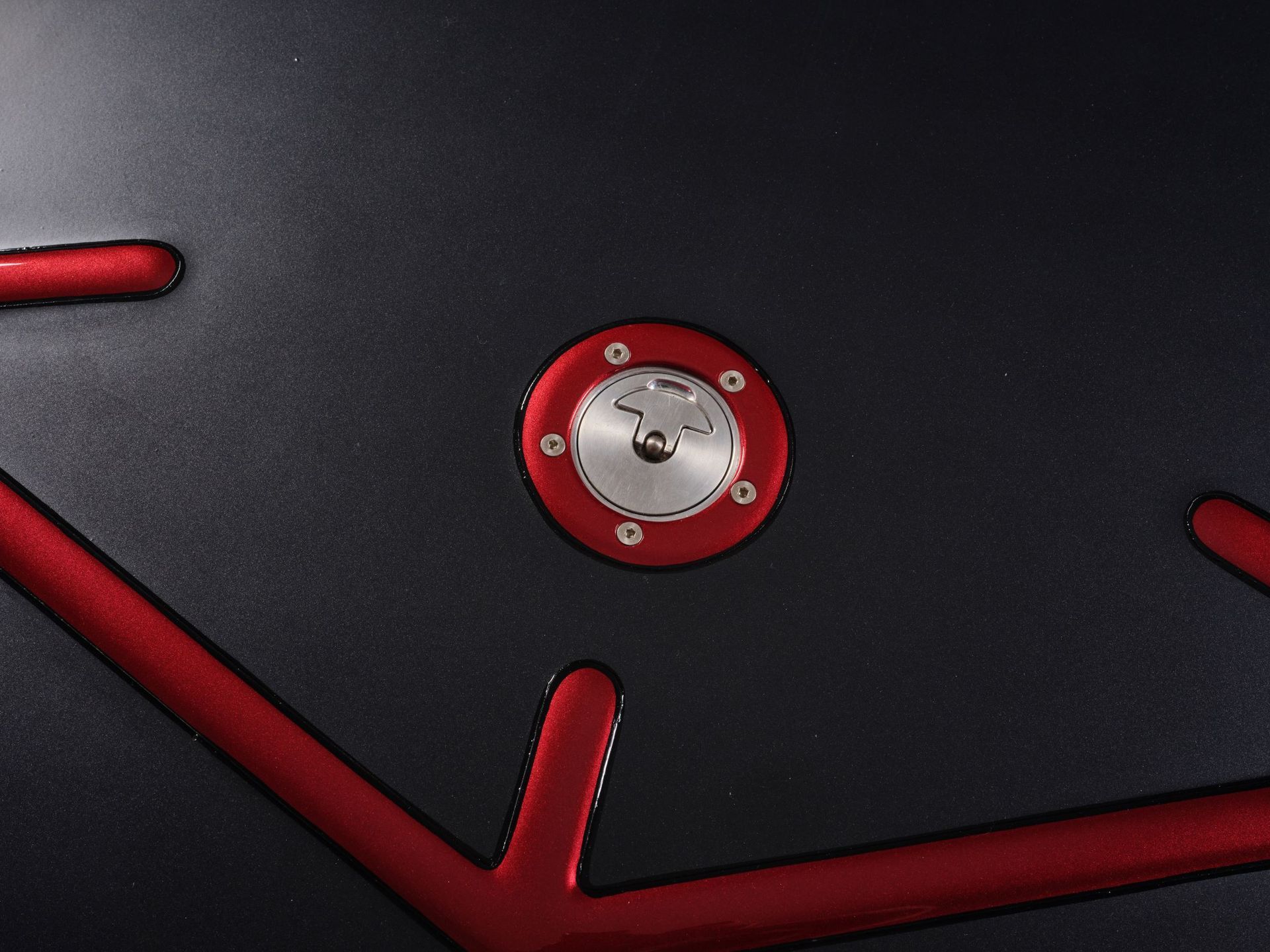 Close-up of a black and red device panel with a central circular metal connector