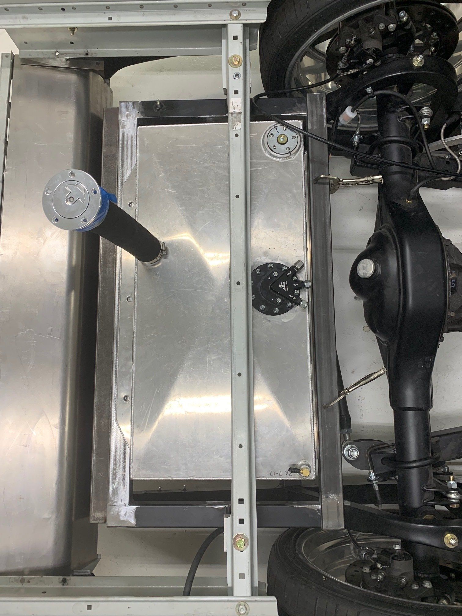 Underbody view of a vehicle chassis with metal panels and suspension components exposed
