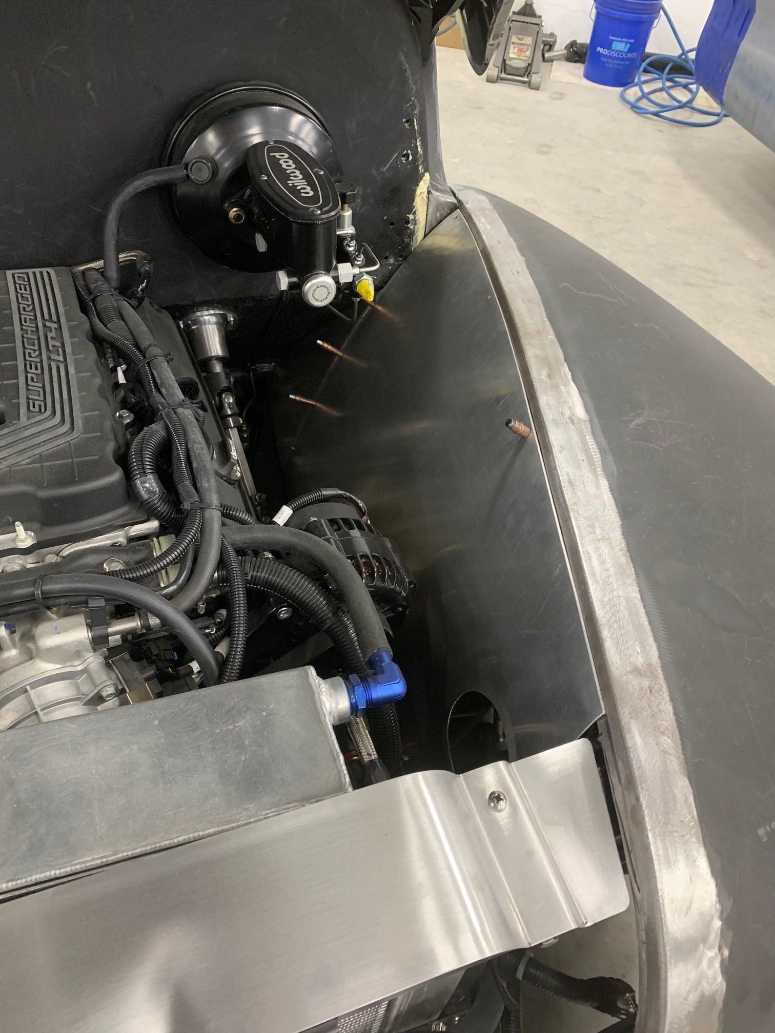 Close-up of an engine bay with black hoses and a silver metal panel inside a vehicle