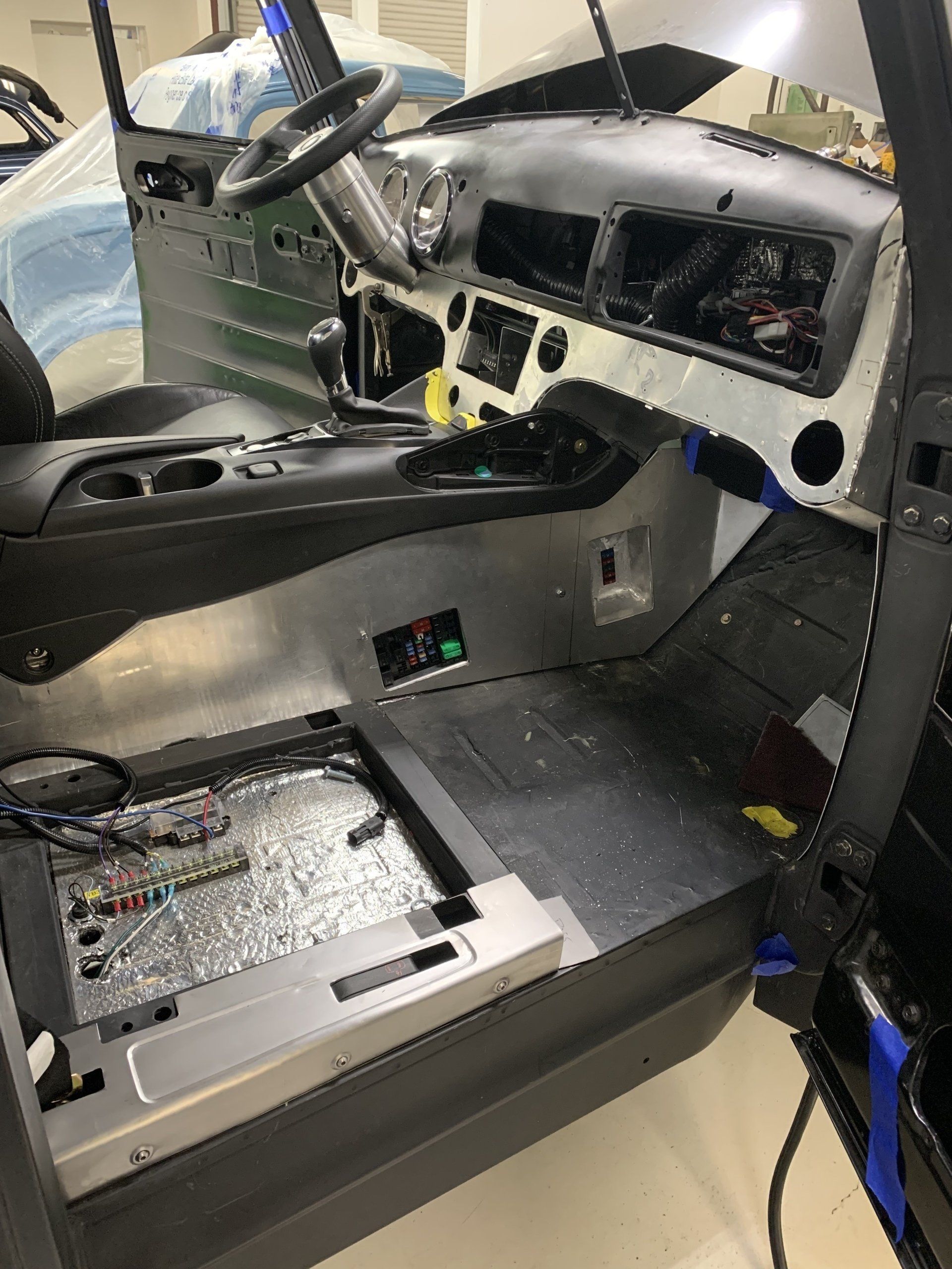 Damaged car interior with exposed dashboard, missing seats, and debris after a crash