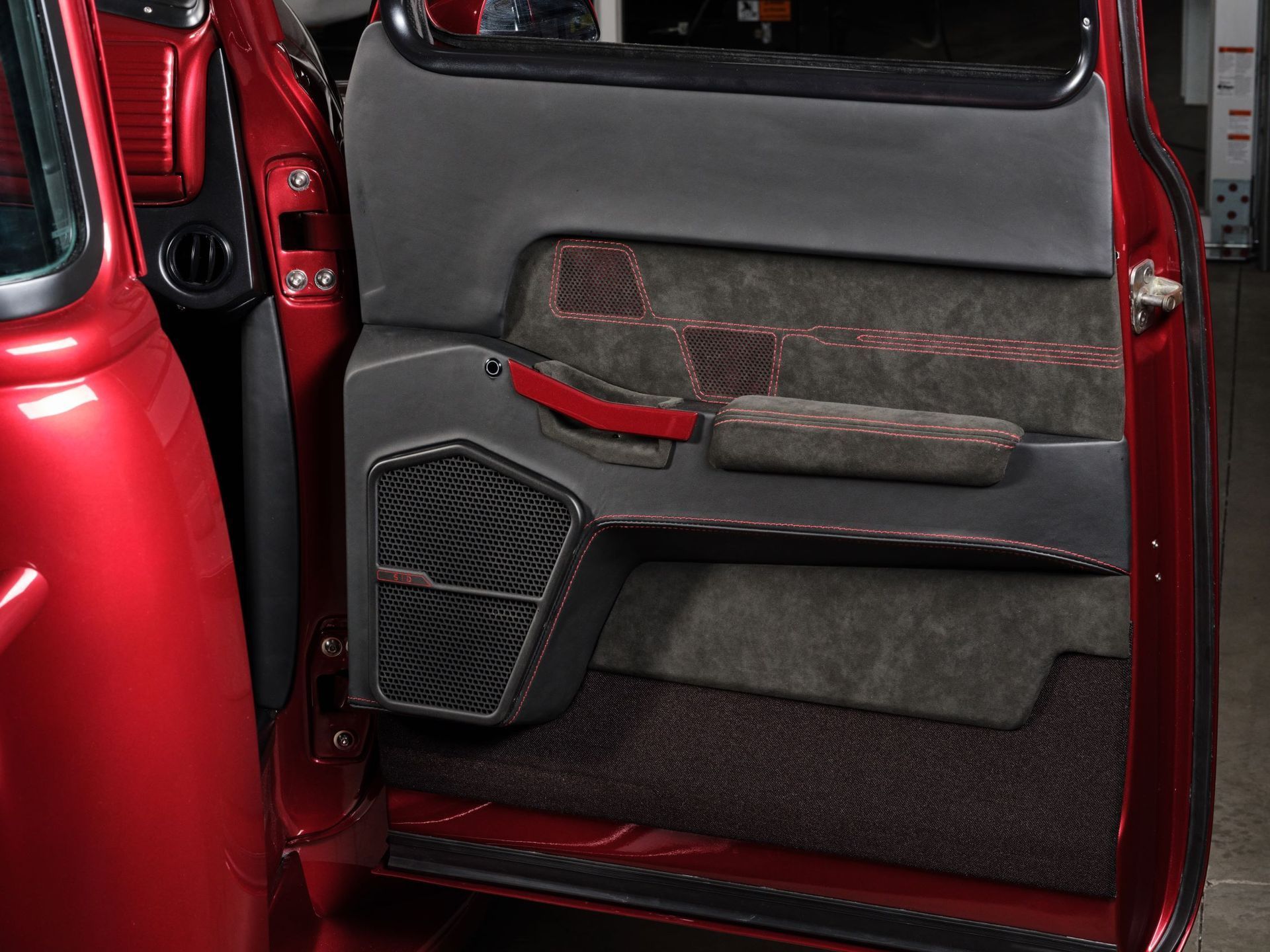 Close-up of a red car interior door panel with black and gray upholstery.