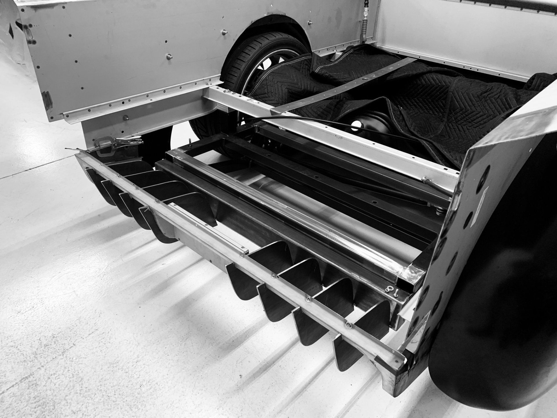 Close-up of a mechanical assembly with metal rails and a black wheel inside a machine.