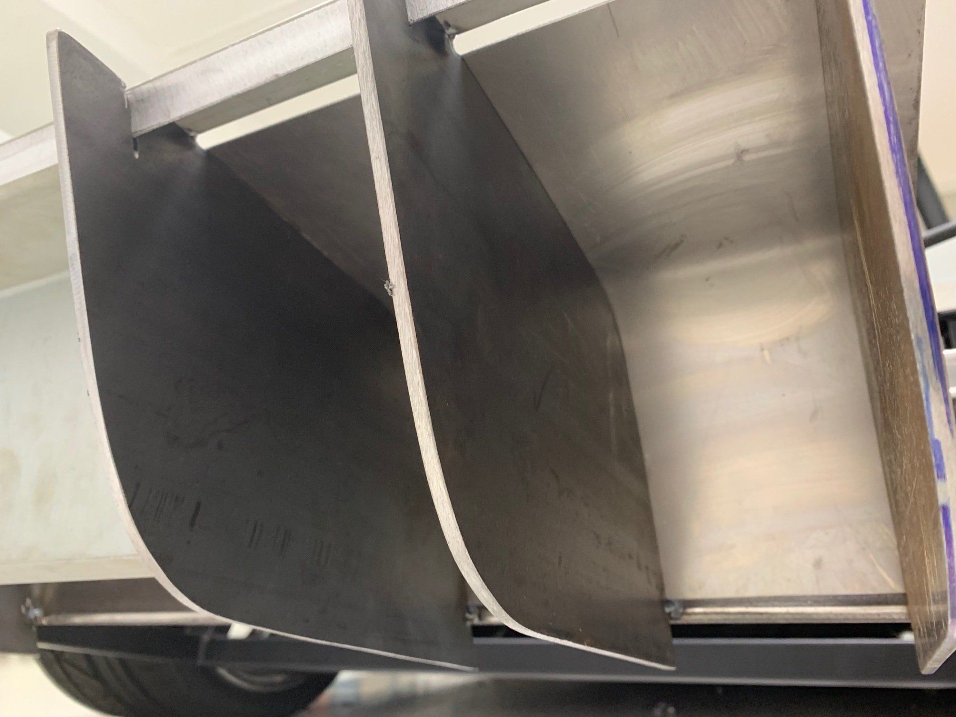 Black and silver curved metal panels inside a machine or industrial enclosure