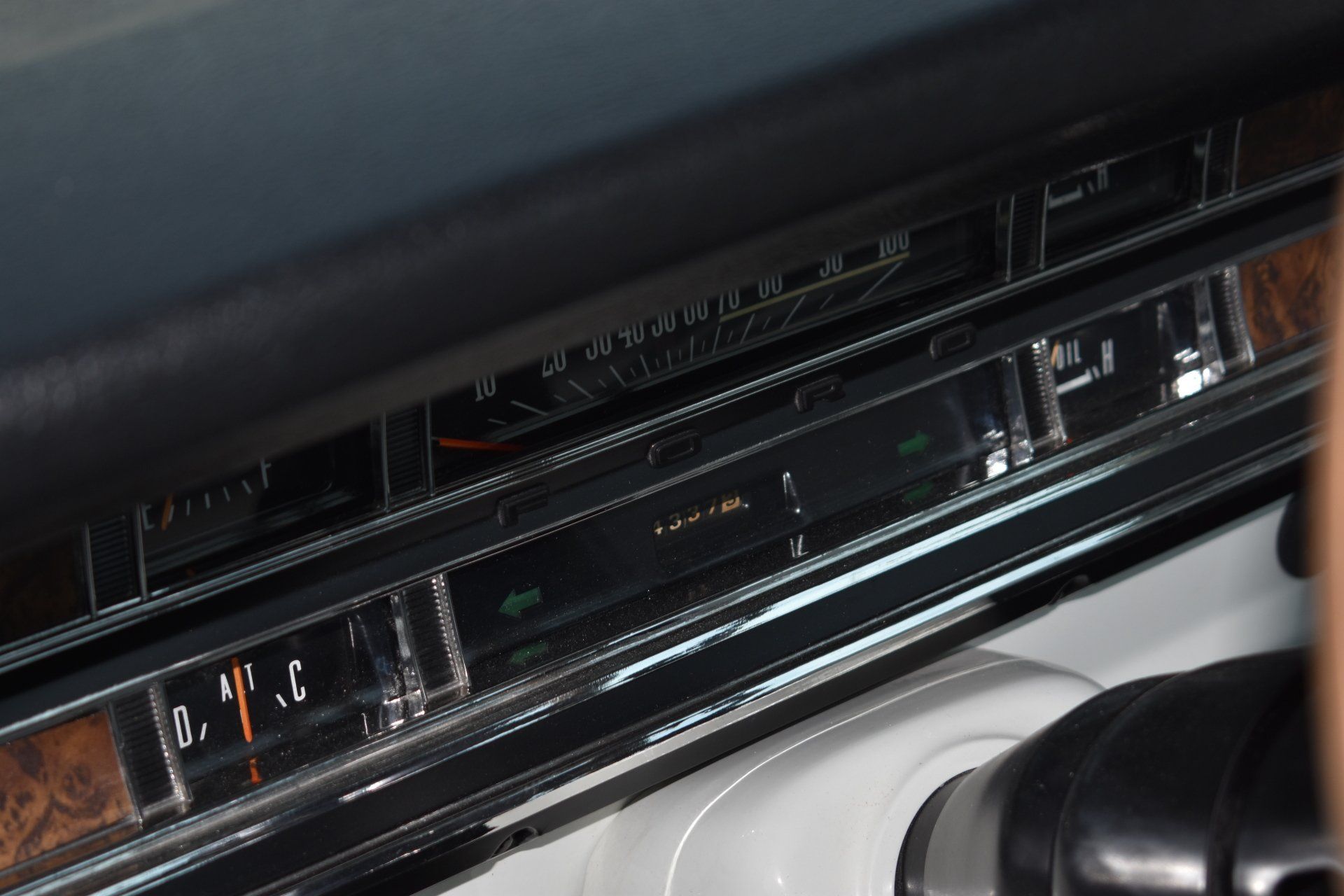 Close-up of a vintage car dashboard radio and climate controls in a black interior
