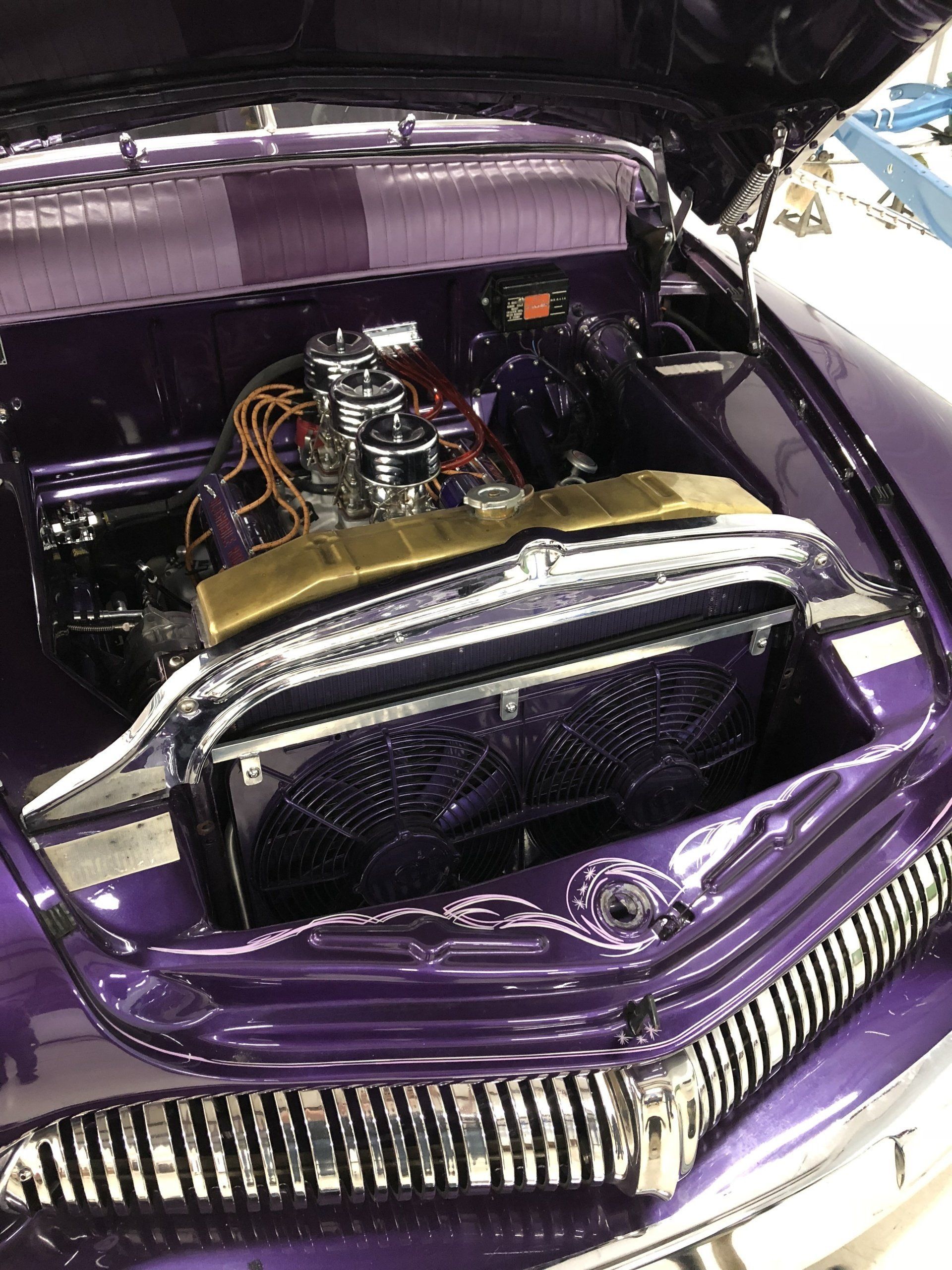 Purple classic car engine bay with chrome air cleaner and polished radiator, hood open
