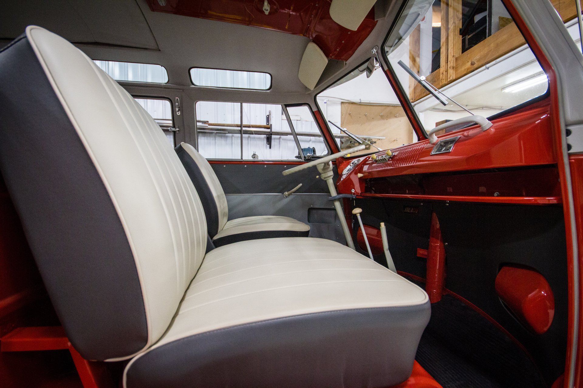 Interior of a vintage car with white and red seats and a red dashboard