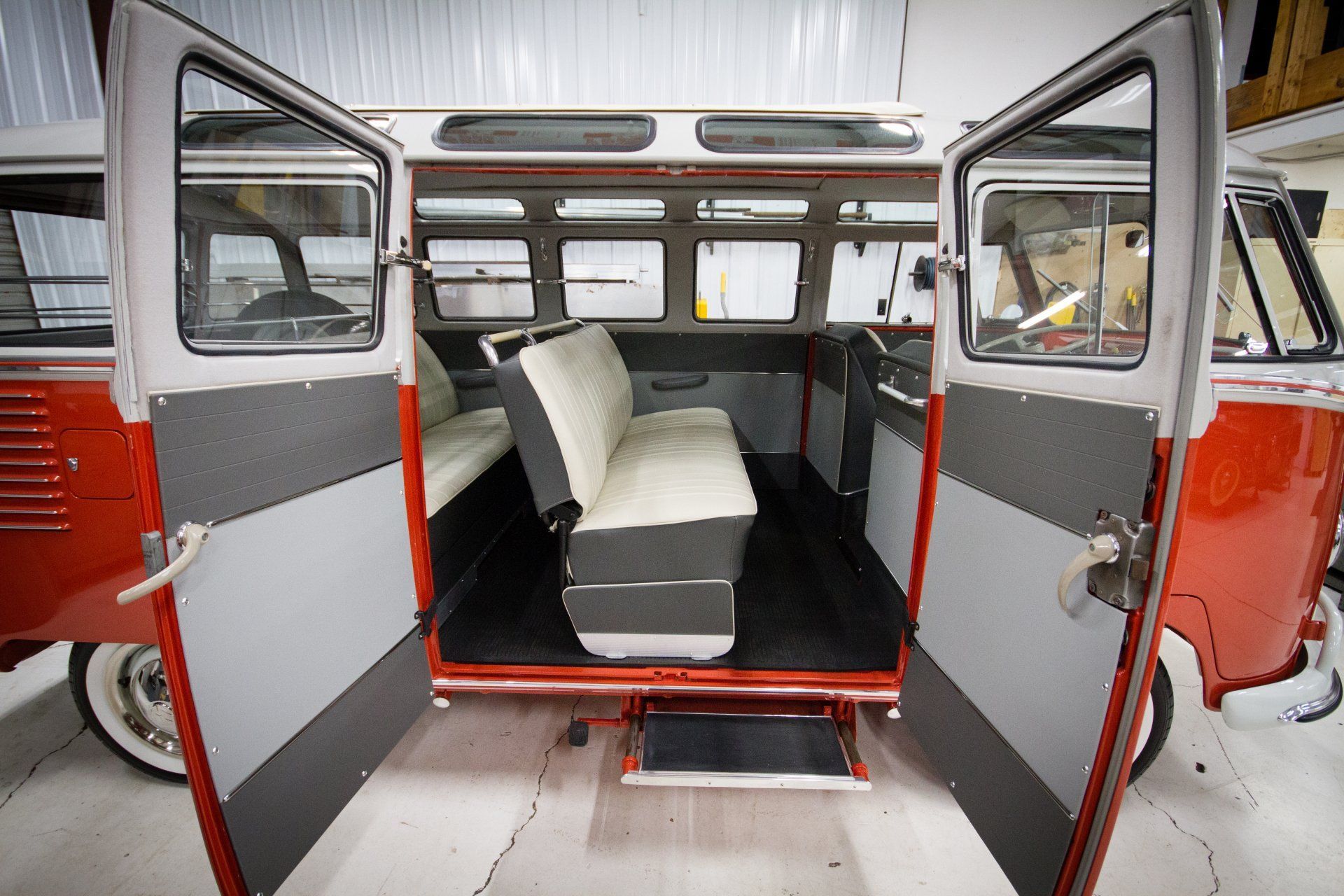 Interior of a red van with open rear doors and a bench seat inside