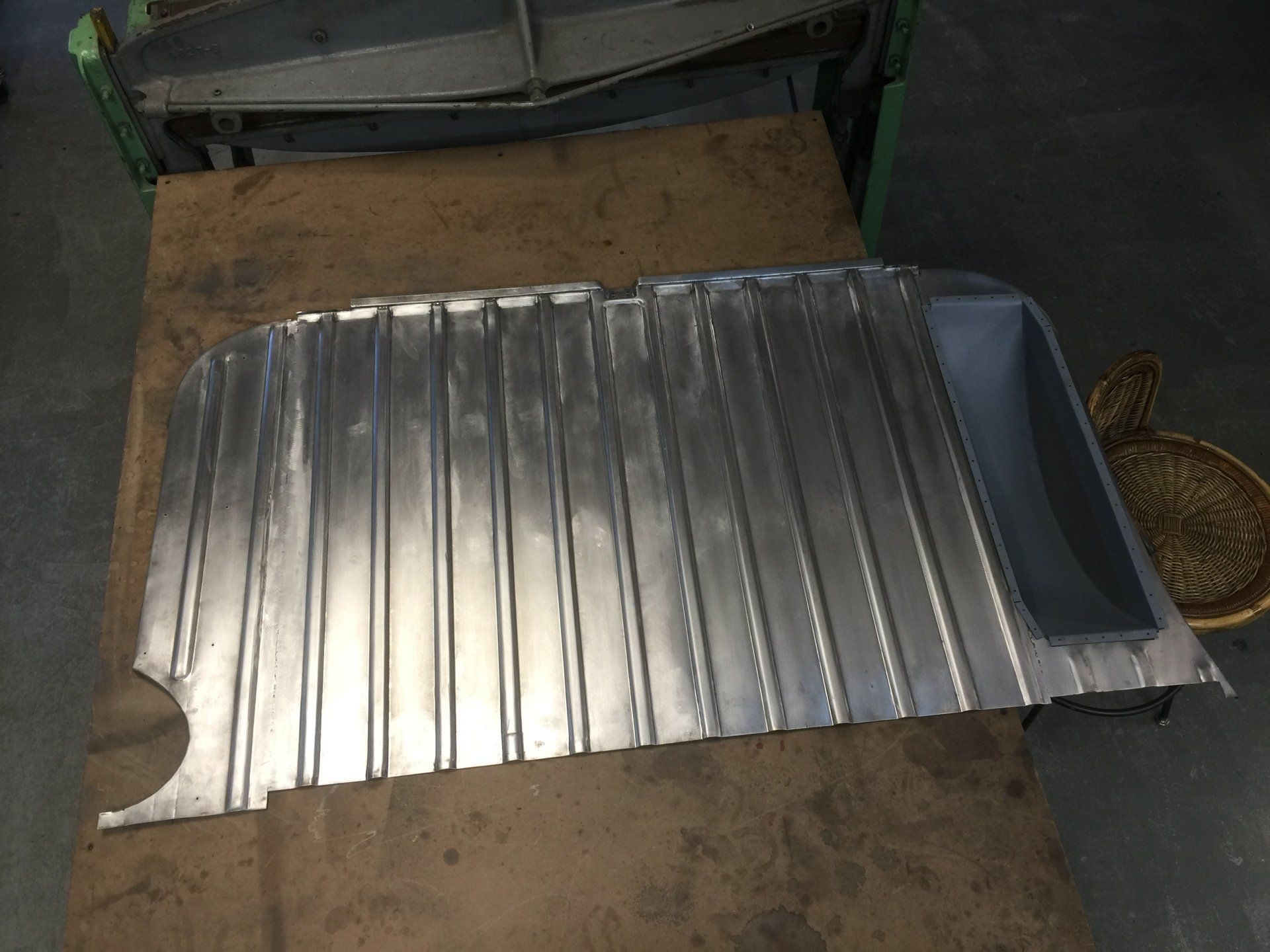 Corrugated metal sheet with a bent edge lying on a wooden work surface