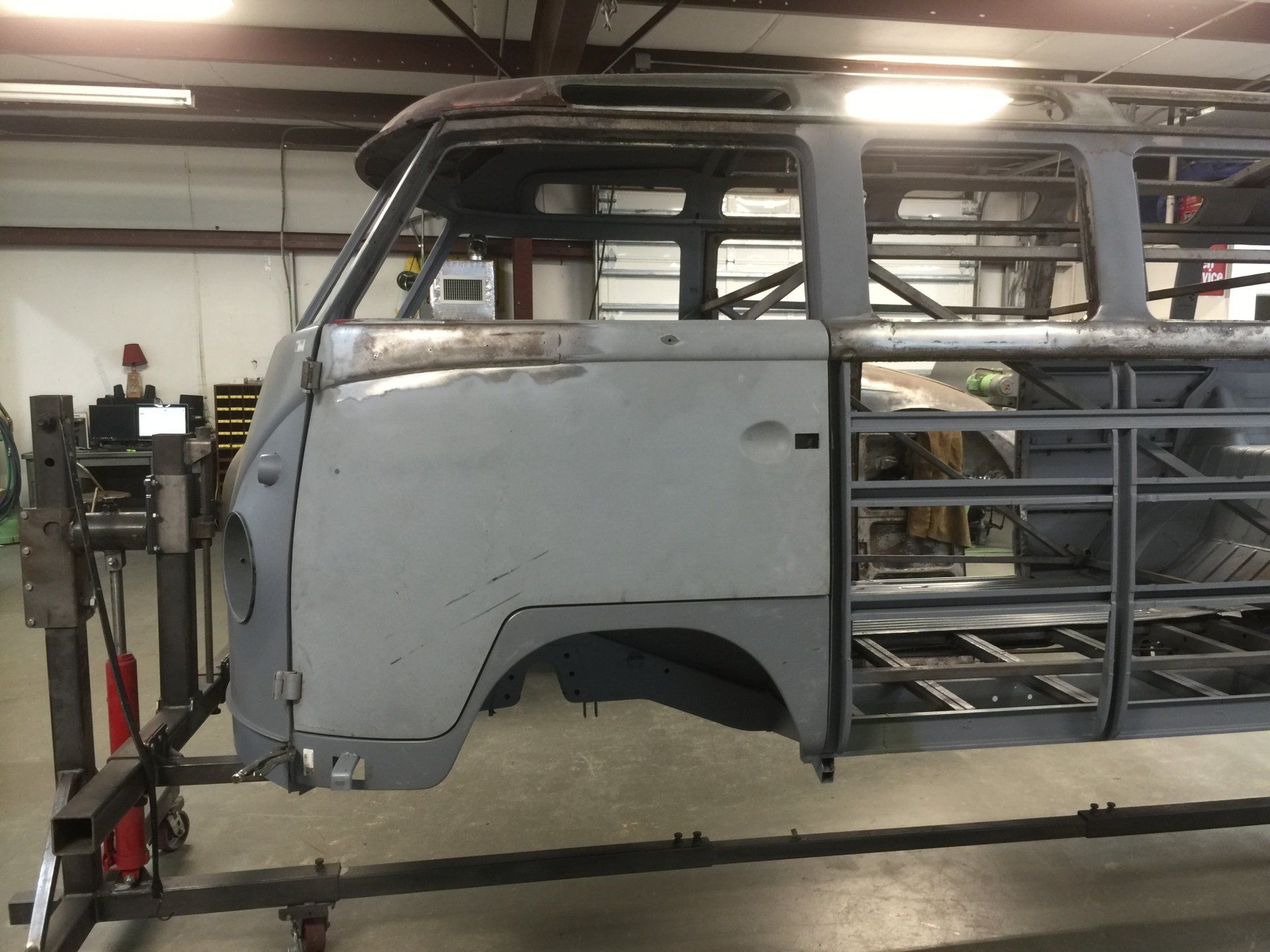 Gray vintage truck body shell on a stand in an industrial workshop