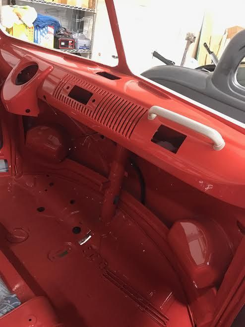 Red car interior being repainted, with glossy red dashboard and empty front cabin.