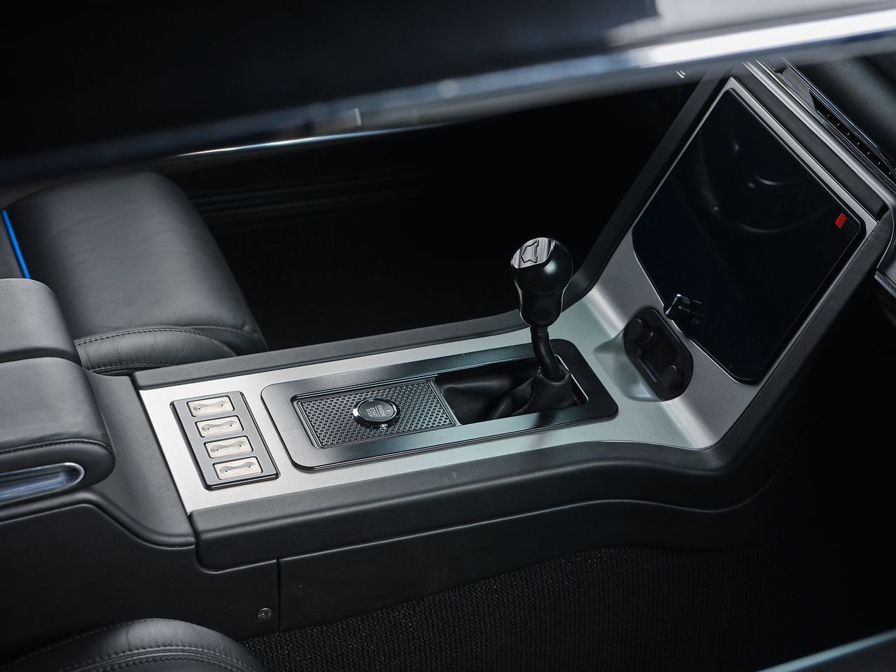 Close-up of a black car interior with a blue-accented leather seat and dashboard trim