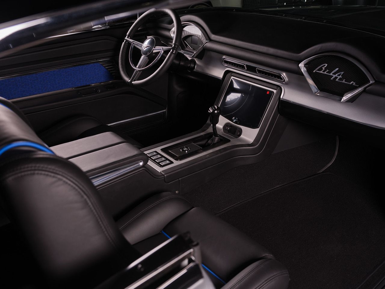 Luxury car interior with black leather seats, blue accents, and a center console touchscreen
