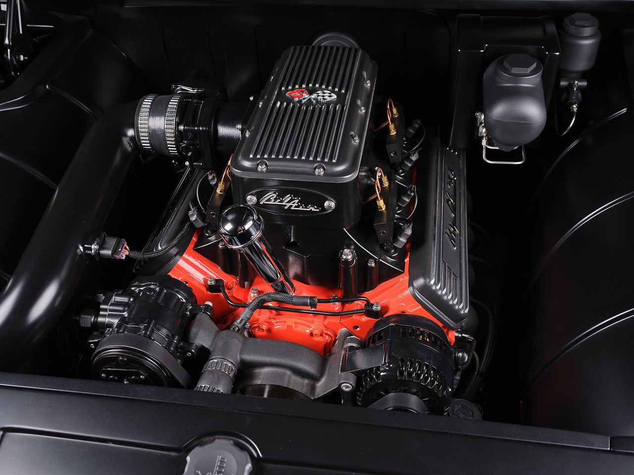 Black car engine bay with a red and black performance engine